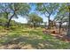 Large backyard with mature trees, a playground, fire pit, and comfortable seating area for outdoor entertainment at 2369 Rice Pond Rd, Charleston, SC 29414