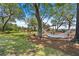 Spacious backyard featuring mature trees, a hammock, playground, and a charming seating area with fire pit at 2369 Rice Pond Rd, Charleston, SC 29414