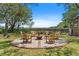 Lush backyard seating area features an outdoor fire pit with Adirondack chairs with scenic water view at 2369 Rice Pond Rd, Charleston, SC 29414