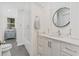 Bathroom vanity with marble countertop and round mirror, with access to a full shower/bath at 2369 Rice Pond Rd, Charleston, SC 29414