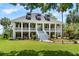 Elegant two-story home with a welcoming porch, landscaped yard, and classic architectural details at 2369 Rice Pond Rd, Charleston, SC 29414