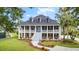 Captivating two-story home boasting a double porch, a well-manicured lawn, and a gracefully curved walkway at 2369 Rice Pond Rd, Charleston, SC 29414