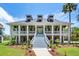 Stunning two-story home featuring a double porch, beautiful landscaping, and an inviting staircase leading to the front door at 2369 Rice Pond Rd, Charleston, SC 29414