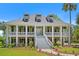 Charming two-story home with a spacious double porch,dormers, and landscaped front yard, creating a welcoming curb appeal at 2369 Rice Pond Rd, Charleston, SC 29414