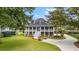 Beautifully landscaped yard with a two-story home featuring a large porch and classic design at 2369 Rice Pond Rd, Charleston, SC 29414