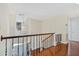 Upstairs hallway with hardwood floors, iron railings, and modern chandelier at 2369 Rice Pond Rd, Charleston, SC 29414
