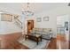 Open-concept living room with hardwood floors, gray sofa, bar cabinet, columns, and view into adjacent room at 2369 Rice Pond Rd, Charleston, SC 29414
