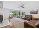 Spacious living room with fireplace, leather seating, ceiling fan, and windows overlooking the back yard at 2369 Rice Pond Rd, Charleston, SC 29414