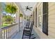 Inviting porch featuring comfortable rocking chairs, ceiling fans, and views of the lush surroundings at 2369 Rice Pond Rd, Charleston, SC 29414