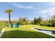 Beautiful backyard featuring pool, grass, and chairs with scenic marsh views and palm trees at 2618 Raven Dr, Sullivans Island, SC 29482
