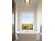 Luxurious bathroom featuring a standalone tub and large windows offering a serene view at 2618 Raven Dr, Sullivans Island, SC 29482