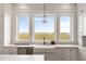 Farmhouse sink beneath three windows offering expansive marsh views in the gourmet kitchen at 2618 Raven Dr, Sullivans Island, SC 29482