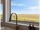 Bright kitchen window offering scenic marsh views and clear blue sky, enhancing the home's natural light and appeal at 2618 Raven Dr, Sullivans Island, SC 29482
