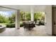 Covered patio with comfortable seating and travertine floor overlooking the garden at 2618 Raven Dr, Sullivans Island, SC 29482