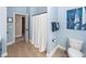 Light blue bathroom with neutral tile and an open door and a shower with white shower curtain at 2632 Alderly Ln, Mount Pleasant, SC 29466