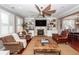 Cozy living room with built-ins, a fireplace, ceiling fan, and large windows offering plenty of natural light at 2632 Alderly Ln, Mount Pleasant, SC 29466
