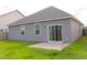View of the backyard with sliding glass doors leading to a concrete patio at 303 Citation Way, Moncks Corner, SC 29461