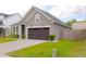 Single Gathering home features a 2-car garage, manicured lawn and neutral siding with a dark roof at 303 Citation Way, Moncks Corner, SC 29461