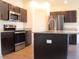 Modern kitchen with dark wood cabinets, stainless steel appliances, granite counters, and kitchen island at 303 Citation Way, Moncks Corner, SC 29461