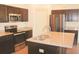 Modern kitchen features stainless appliances, dark cabinets, and a kitchen island with granite countertops at 303 Citation Way, Moncks Corner, SC 29461