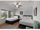 Bright bedroom with two beds, large windows, and a ceiling fan at 31 W 9Th St, Folly Beach, SC 29439
