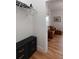 Hallway with wood floors leading to a living room and a small closet with black drawers at 31 W 9Th St, Folly Beach, SC 29439