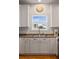 Bright kitchen with white cabinets, stainless steel sink, and view of building exterior at 31 W 9Th St, Folly Beach, SC 29439