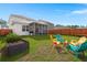 Inviting backyard with a fire pit, colorful Adirondack chairs, and well-manicured lawn at 315 Black Birch Dr, Summerville, SC 29486