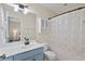 Stylish bathroom with blue vanity, modern fixtures, and a shower-tub combo with patterned curtain at 417 Verbena Ave, Summerville, SC 29483