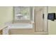 A view of a soaking tub, shower and arched window in this bright bathroom at 4209 Wildwood Lndg, Charleston, SC 29420