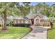 Beautiful brick home featuring a well-maintained lawn, mature trees, and a circular driveway at 4209 Wildwood Lndg, Charleston, SC 29420