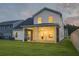 A beautiful backyard with a covered porch, lush green lawn, and a two-story home at dusk at 4374 Cotton Flat Rd, Summerville, SC 29485