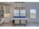 Bright dining area with white marble dining table, white chairs, banquette seating, and designer chandelier at 4374 Cotton Flat Rd, Summerville, SC 29485
