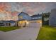 Charming two-story home with a well-manicured lawn, three-car garage, and an inviting front porch at 4374 Cotton Flat Rd, Summerville, SC 29485