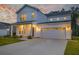 Charming two-story home with white siding, a welcoming front porch, a wide driveway and a two-car garage at 4374 Cotton Flat Rd, Summerville, SC 29485