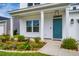Inviting front porch with a teal door, fresh landscaping, and well-maintained lawn enhances curb appeal at 4374 Cotton Flat Rd, Summerville, SC 29485