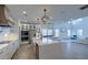 Bright, open-concept kitchen with white cabinets, quartz countertops, stainless appliances, and elegant pendant lighting at 4374 Cotton Flat Rd, Summerville, SC 29485