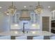 Stylish kitchen with a kitchen island, farmhouse sink, modern faucet, and elegant chandelier lighting at 4374 Cotton Flat Rd, Summerville, SC 29485