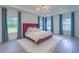 Spacious primary bedroom featuring a tray ceiling, generous natural light, and elegant decor with light wood flooring at 4374 Cotton Flat Rd, Summerville, SC 29485
