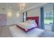 Bright primary bedroom features a tray ceiling, generous natural light, and elegant decor with light wood flooring at 4374 Cotton Flat Rd, Summerville, SC 29485