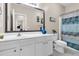 Bright bathroom with white cabinets, a large mirror, and a shower with a colorful curtain at 5013 Franconia Dr, Summerville, SC 29485