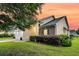 Charming home with manicured lawn, brick accents, and lush landscaping against a colorful sunset sky at 5013 Franconia Dr, Summerville, SC 29485