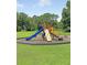 A colorful community playground featuring a slide, climbing wall and swings set in a grassy area at 5013 Franconia Dr, Summerville, SC 29485