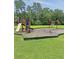 A colorful community playground featuring a slide, climbing wall, and swings set in a grassy area at 5013 Franconia Dr, Summerville, SC 29485