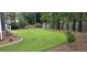 Spacious backyard with green lawn, privacy fence, garden bed, and established trees that offer privacy and beauty at 5540 Indigo Fields Blvd, North Charleston, SC 29418