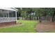 Well-manicured backyard featuring a screened porch, lush lawn, and privacy fence with appealing landscaping at 5540 Indigo Fields Blvd, North Charleston, SC 29418
