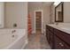 Bright bathroom featuring a bathtub, dual sink vanity, walk-in closet, and neutral tones at 5540 Indigo Fields Blvd, North Charleston, SC 29418