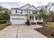 Charming two-story home with a front porch, attached garage, and well-manicured landscaping at 5540 Indigo Fields Blvd, North Charleston, SC 29418
