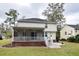 Back of the home featuring a screened porch and well-maintained lawn with mature trees at 5540 Indigo Fields Blvd, North Charleston, SC 29418
