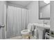 Cozy bathroom featuring a pedestal sink, toilet, and a shower with a white curtain at 607 Greencastle Dr, Goose Creek, SC 29445